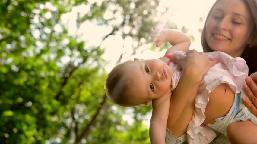 Mother and Baby Outdoor. Playing Together in Green Park. Happy Family Smiling