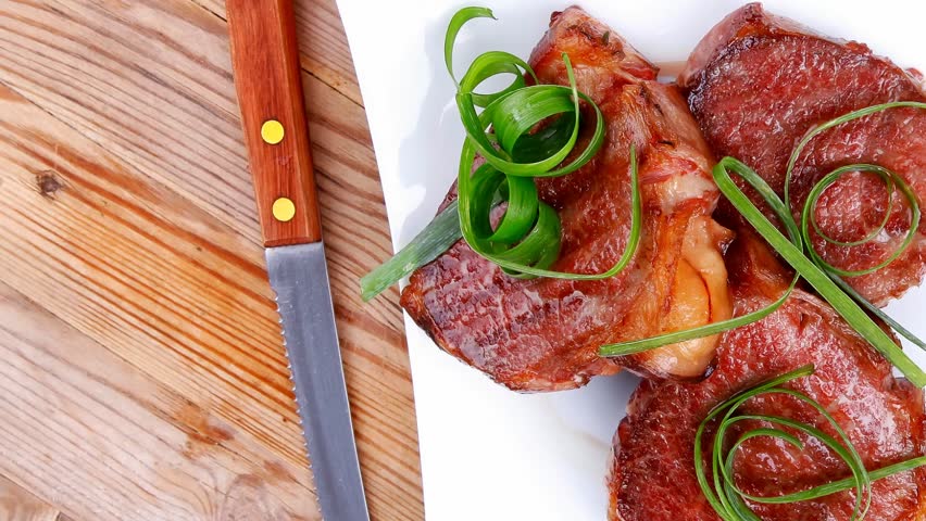 grilled meat beef steaks strips plate with pepper and cutlery over wood table 1920x1080 intro motion slow hidef hd