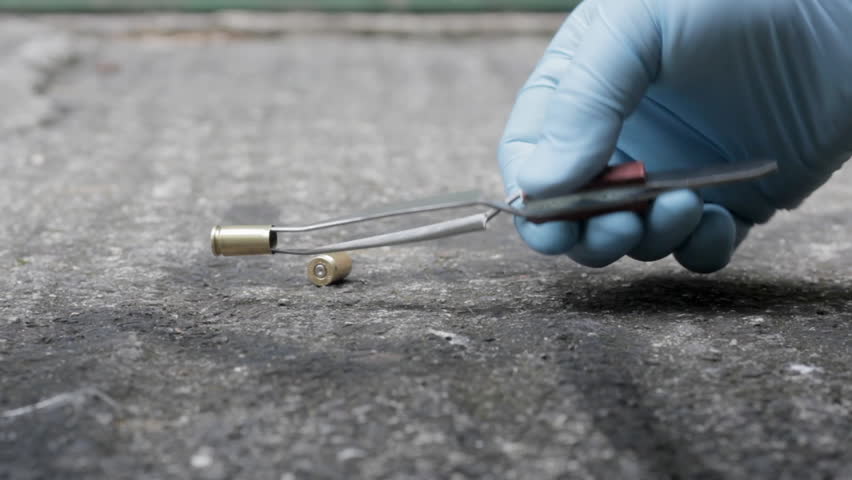 Detective picking up bullet case