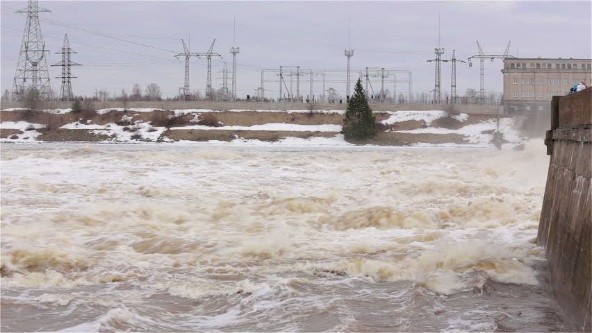 Flood on the river. Flowing water. Hydroelectric power station.