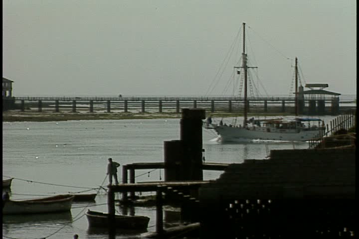 MOMBASA, KENYA, AFRICA - DECEMBER 01, 1998: Scenic shot taken in Mombasa harbor; MS sailboat, without sails, moves quickly through harbor. 
