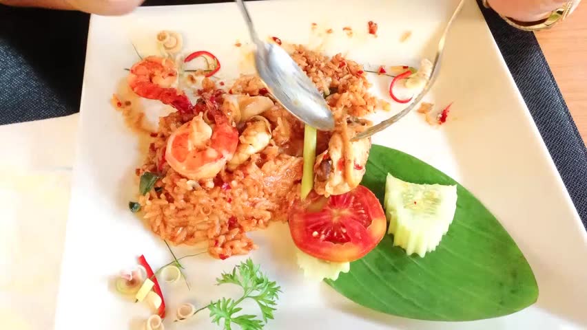 Time lapse of eating spicy seafood fried rice in restaurant