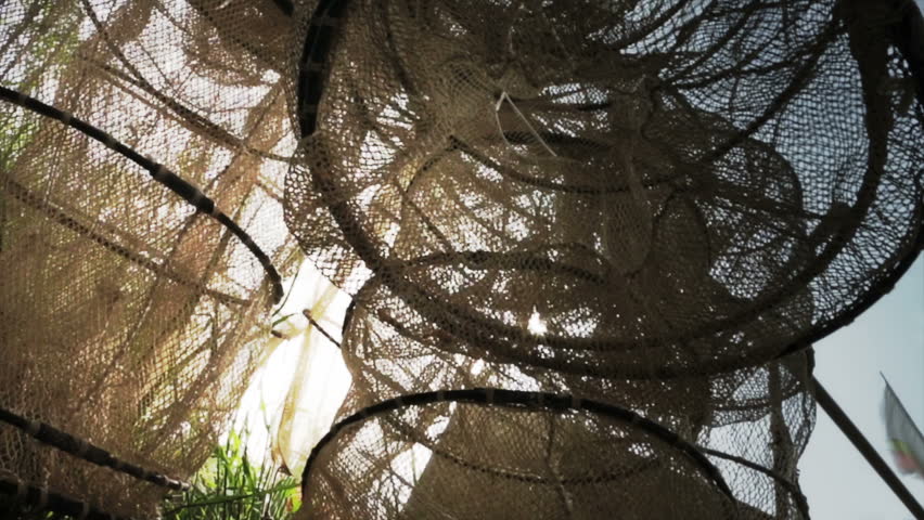 Many fish nets being drying outdoors with form of basket