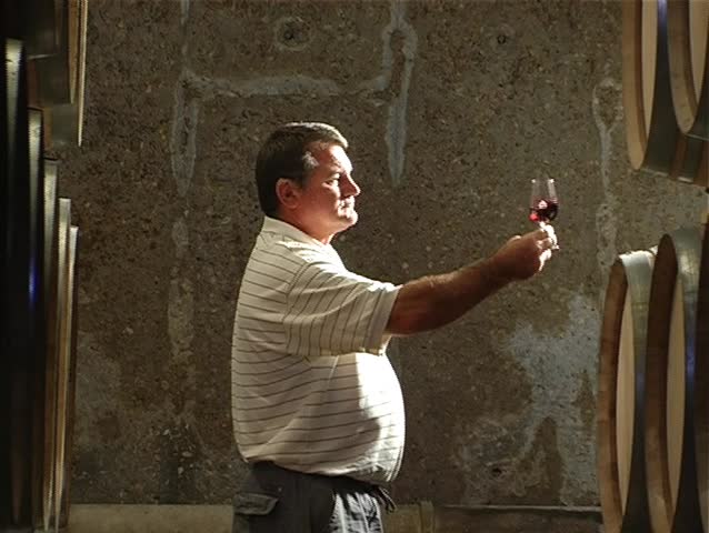 Tracking shot of a winemaker tasting wine medium close up