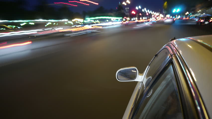 Driving a car time-lapse. Night, Camera gripped on the side / reference. POV - point of view. White car ride. City, blurred motion, fast driving. HD.