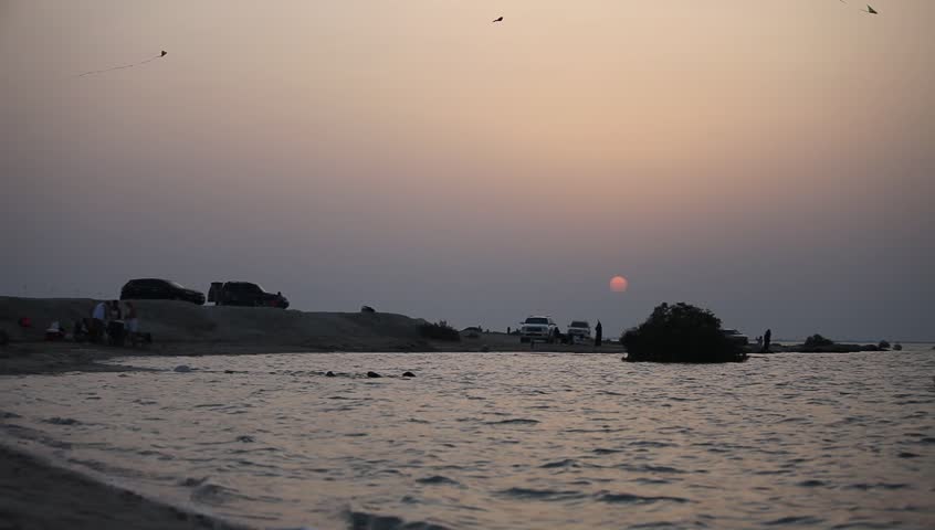 Sunset shot of the beach with kites in the sky
