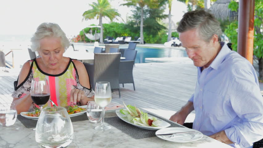 Senior Couple Enjoying Meal In Outdoor Restaurant
