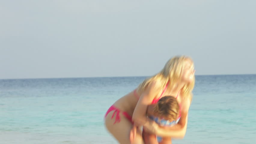 Mother And Daughter Having Fun In Sea On Beach Holiday


