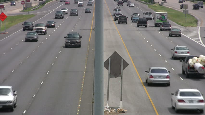 Video of vehicle, car and truck traffic driving both directions view from overpass. High speed multiple lane freeway highway. San Antonio Texas. Don Despain of Rekindle Photo