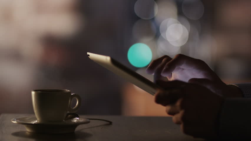 Man Using Tablet PC and Drinking Coffee in Cafe. Close-Up. Shot on RED Digital Cinema Camera in 4K (ultra-high definition (UHD)), so you can easily crop, rotate and zoom, without losing quality!