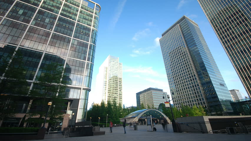 Time lapse of business people traveling in front of corporate office buildings and skyscrapers at Canary Wharf in London