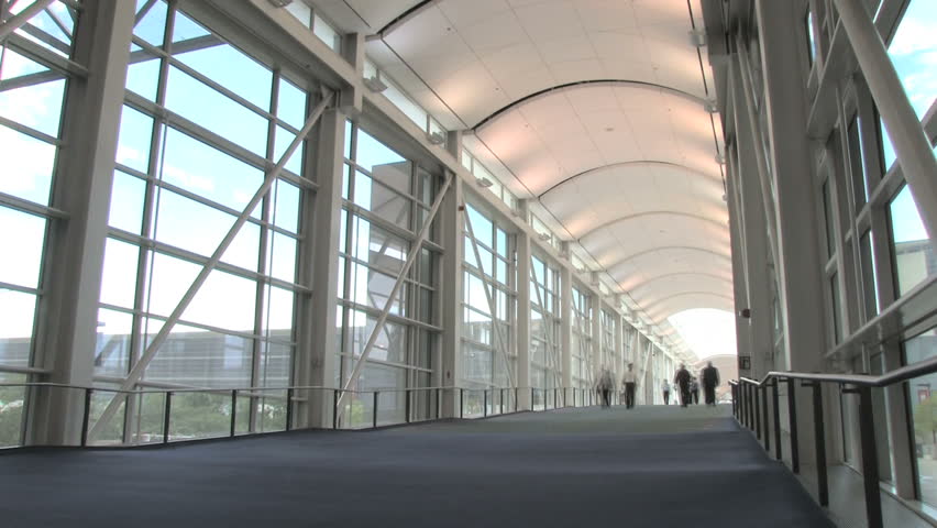 Time lapse, people walking down long corridor with motion blur 
