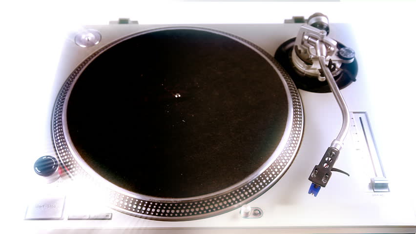 a dj's hand puts a vinyl on a turntable