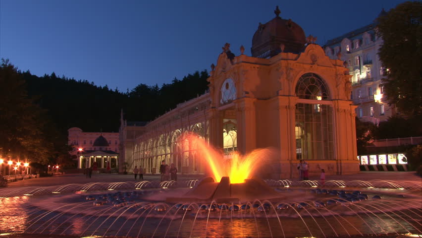 Illuminated Pseudo-Baroque cast iron unique City Colonnade in Marianske Lazne (West Bohemia, Czech) with walking people and fountain. Time lapse.