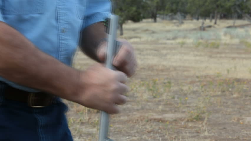 Loading a modern black powder rifle. Fast speed. Dropping powder pellets down the barrel followed by pushing the bullet and sabot down with a ramrod. Primer is placed and rifle is ready to shoot.