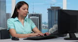 Customer service representative on headset in office overseeing the city skyline