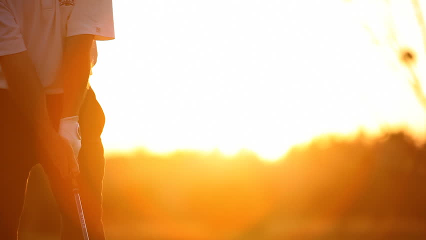 Golf player teeing off on beautiful golf course during dawn