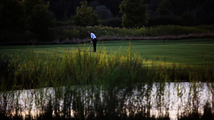 Golf player teeing off on beautiful golf course