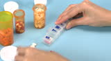 Woman sorting pills into a pill container with compartments for every day of the week