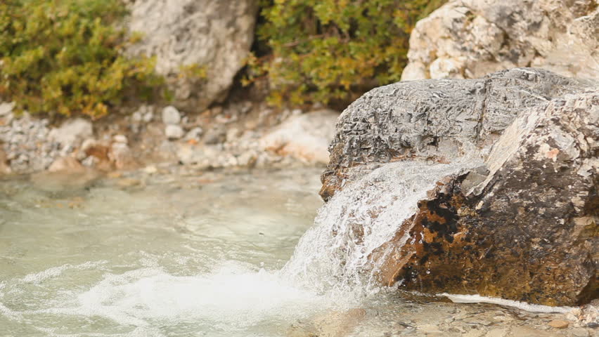 hiking woman drinking water from mountain stream