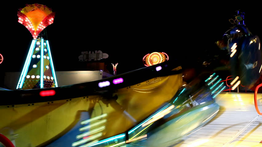 fast spinning carousel illuminated at night with vivid lighting 