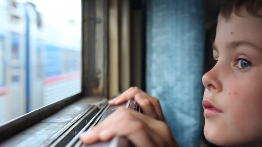 boy looks in window of going train 