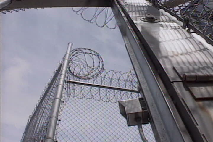 Gates at a prison yard slam shut.