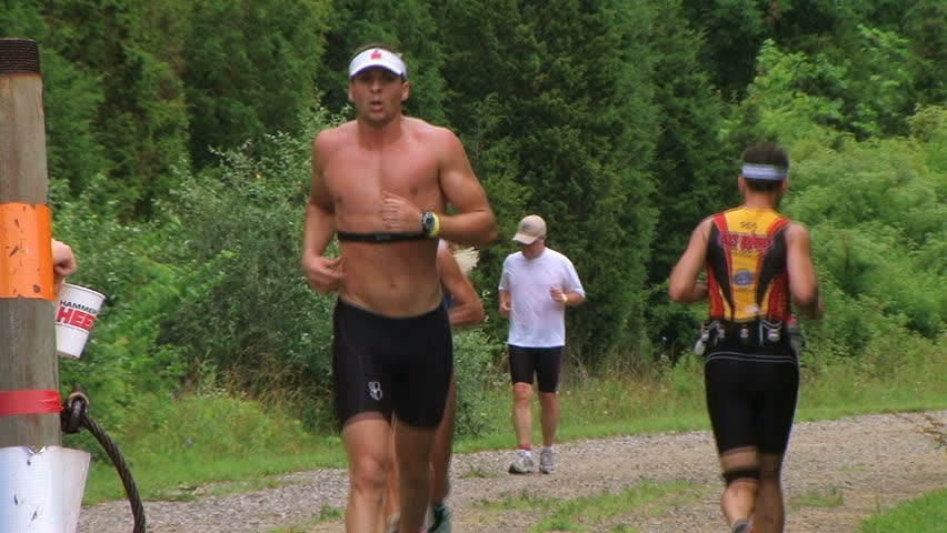 WAYNESVILLE - JULY 5: Runners (names withheld) from Ohio pass at water station during the Caesar Creek Triathlon and Dualthon held at Caesar Creek State Park July 5, 2009 in Waynesville, OH. 