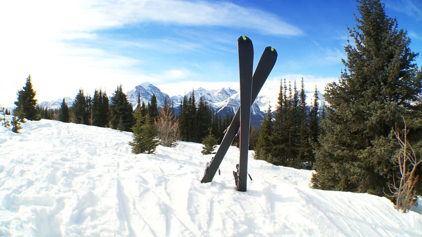 Crossed carver downhill skis standing in fresh clean snow in snowy mountain landscape