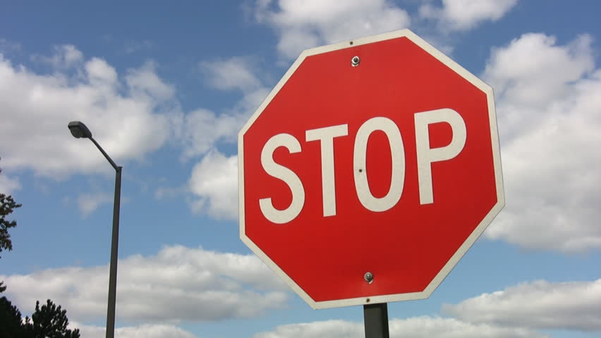 Stop sign with timelapse clouds. HD.