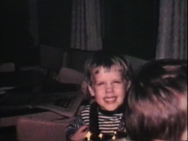 A cute little girl endures the mind numbing glare from the old 8mm camera light while her siblings try to ignore their persistent father.