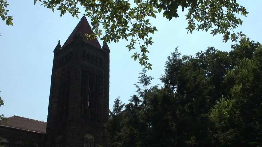 Gothic Bell tower ringing its bell framed with greenery
