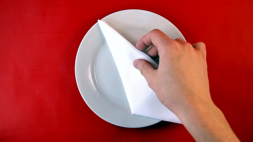 Table appointments- plate, fork, knife serving by human hands on red   background.