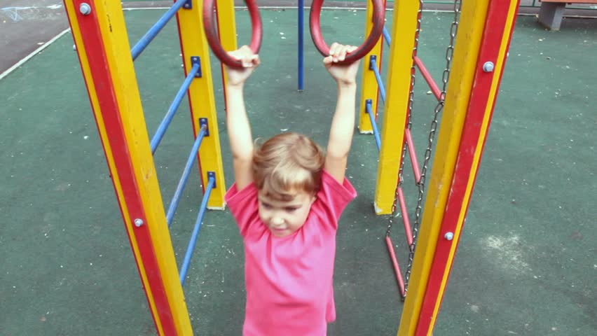 on children's playground on game equipment girl on ladder shakes 