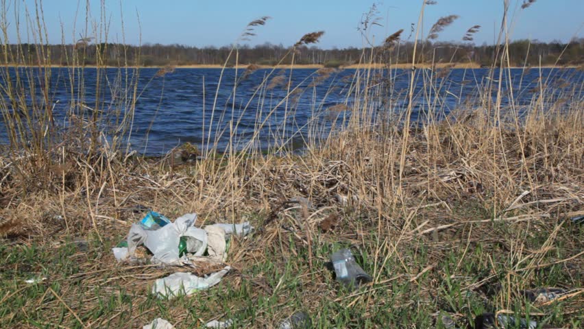 household rubbish on spring polluted bank of river 