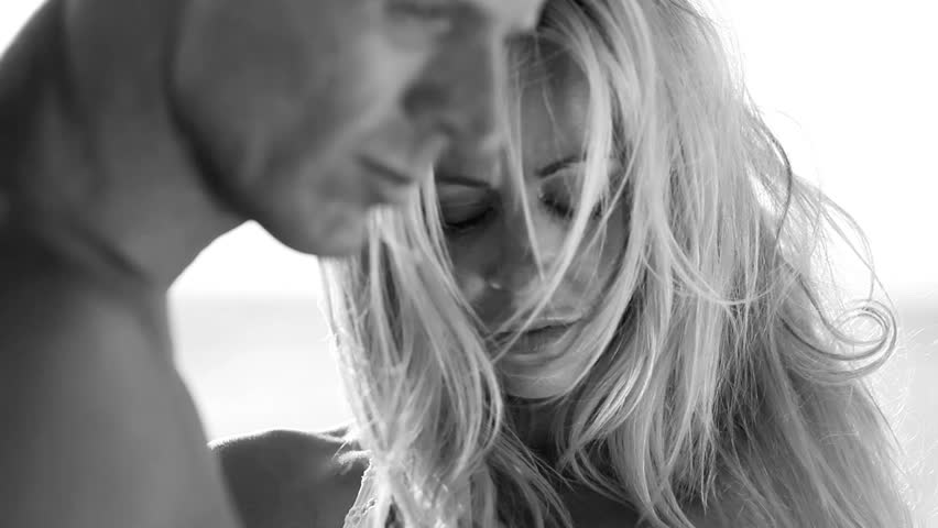 Sensual attractive young couple holding each other outdoors filmed in monochrome
