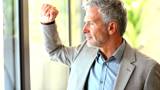 Closeup of senior business man drinking coffee while looking out of window