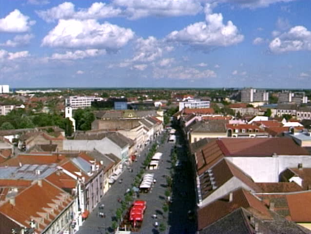 People walking in the street. Clouds passing over a blue sky. Panoramic view.