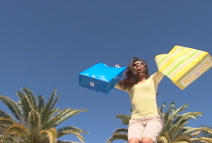 Hispanic woman with shopping bags jumping - slow motion