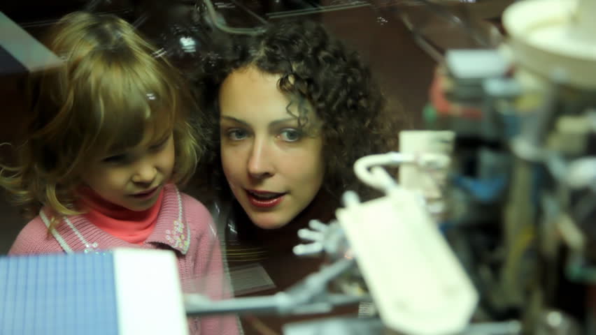mother telling little girl about space exhibit in the space museum 