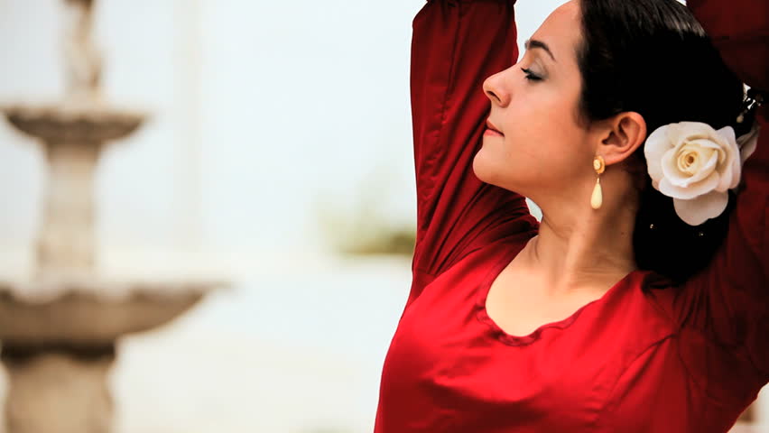Beautiful lady dancing traditional spanish flamenco in town square Seville in close-up