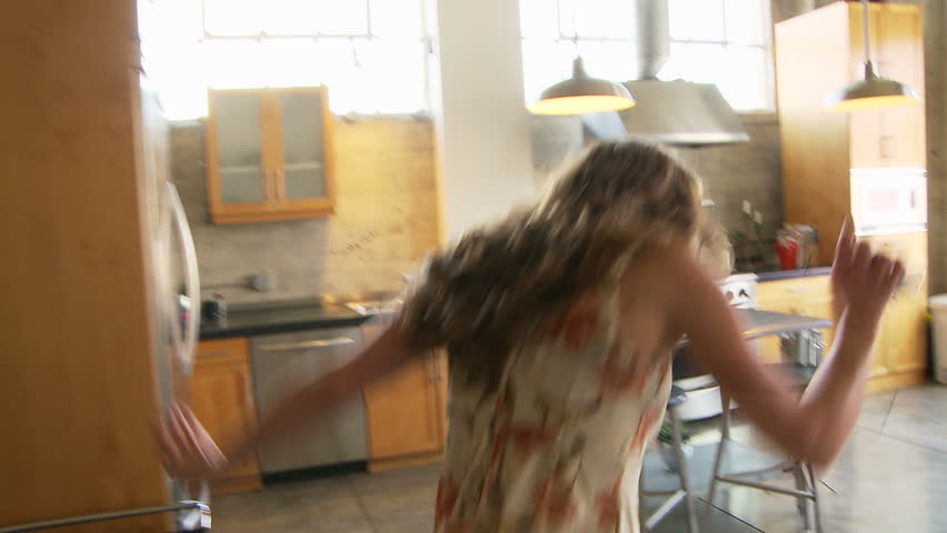 Woman in dress dancing while listening to headphones