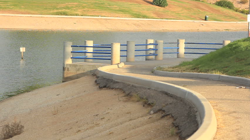 A walkway leads to a pier and overlooks the water's edge.