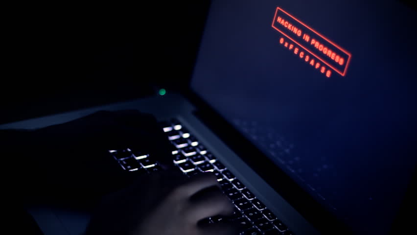 hacker typing on keyboard with a program in the background