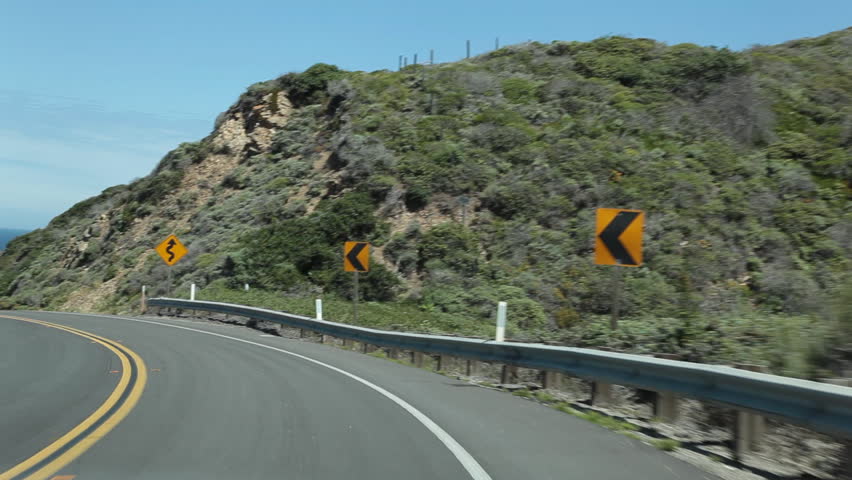 Vehicle point-of-view driving on Highway 1 (Pacific Coast Highway) in the Big Sur area of Central California.  Tripod-mounted camera, however some bounce from car movement is visible.