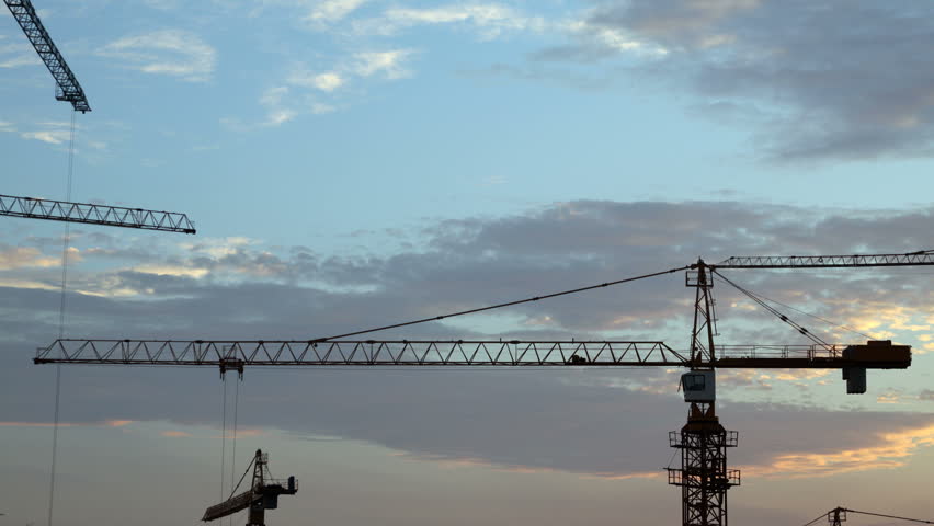 Construction cranes fading in the night, time-lapse
