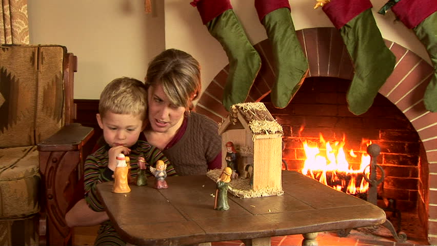 Mother and son with nativity scene at Christmas