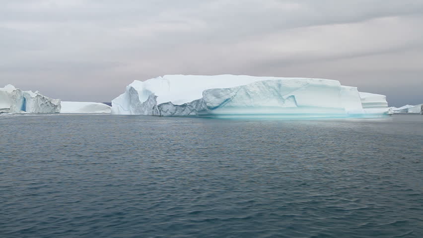 Sailing by an iceberg in the famous Ilulissat icefjord in Greenland. The icefjord is on UNESCO's World Heritage List.