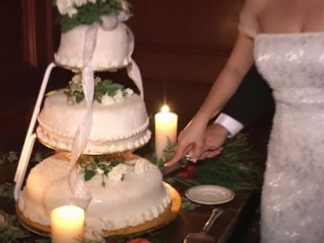 bride and groom are cutting wedding cake