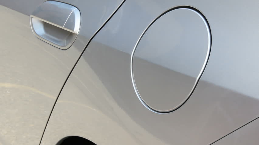 A gasoline nozzle fills the tank of a new hybrid vehicle